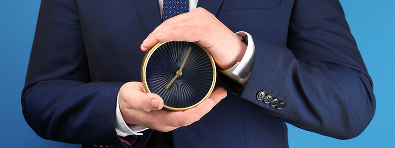 Mann mit Prostataentzündung hält Uhr, die die Dauer der Erkrankung symbolisieren soll.