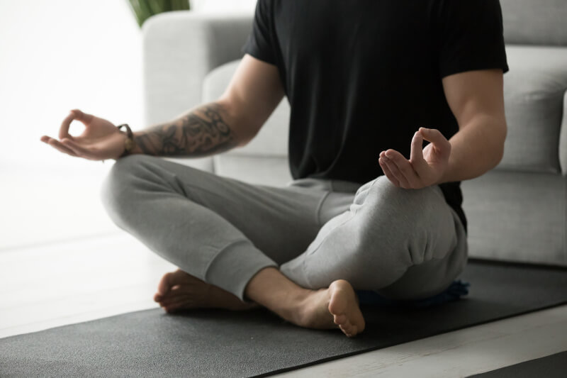 Beckenbodenübung: Ein Mann macht Yoga zur Entspannung der Muskeln.